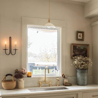 Unlacquered Brass Bridge Kitchen Faucet with Pull Down Sprayer installed in a Vintage Farmhouse Sink